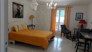 Een slaapkamer met een bed, een bureau, een stoel, een lamp en een kledingkast.