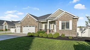 A two-story house with a stone facade, a front porch, and a garage.
