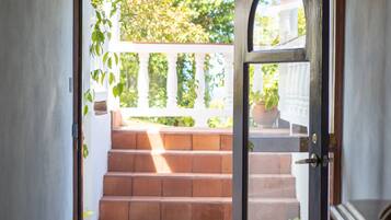 A doorway leading to a staircase with a view of greenery outside.