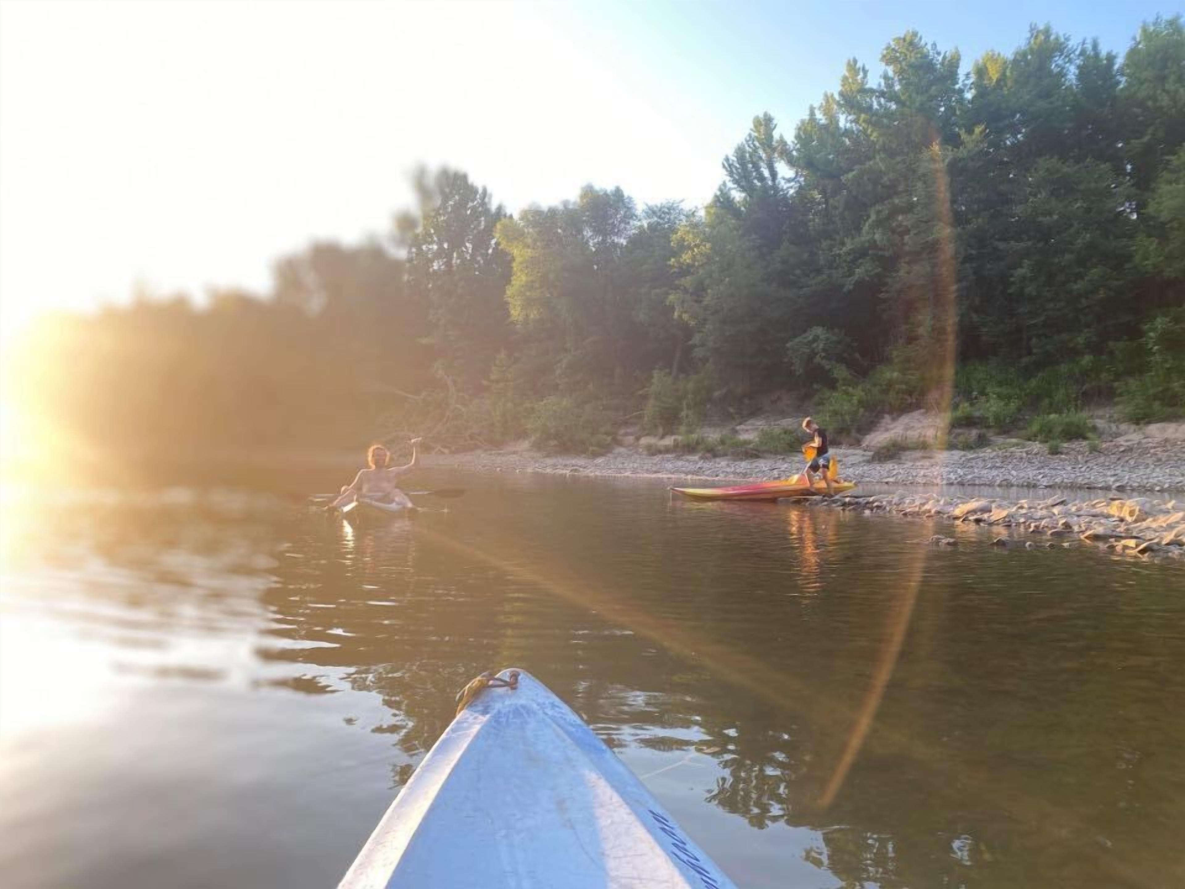 A river scene with kayaks and a person paddling.