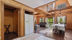 Ein geräumiges Zimmer mit Essbereich, einer Couch und einer Treppe, die zu einer oberen Ebene führt.