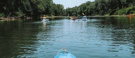 A river scene with kayaks and a person paddling.