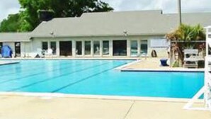 A swimming pool area with a building in the background.