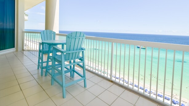 Un balcon avec vue sur l’océan, comprenant une table et deux chaises.