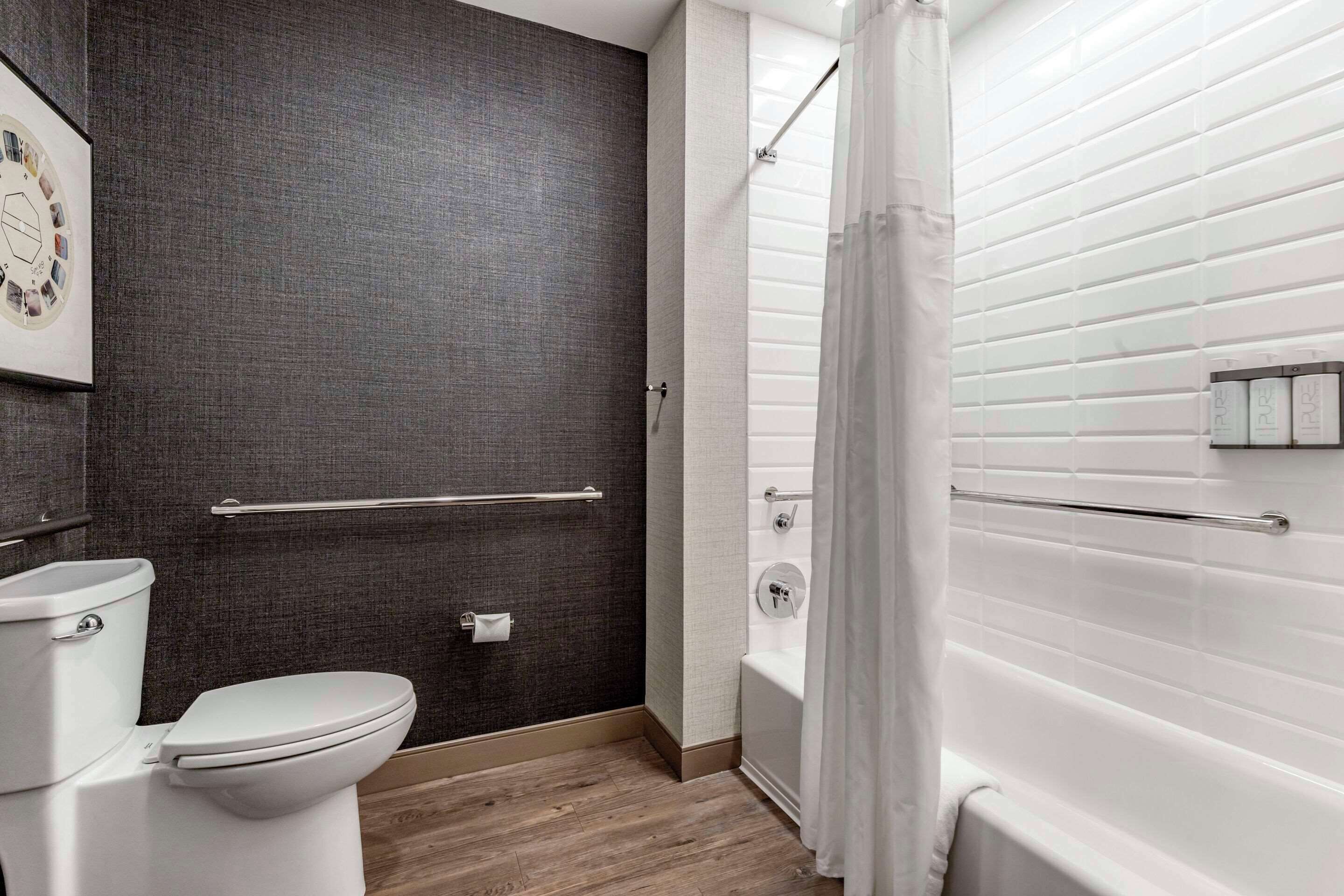A modern bathroom with a toilet, a shower with a glass door, and a towel rack.
