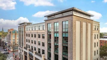 A multi-story building with a brick facade, large windows, and a flat roof.