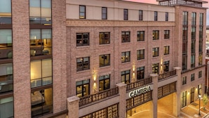 Un hotel de varios pisos con fachada de ladrillo, amplias ventanas y un letrero que dice 'CAMERA'.