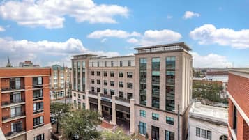 A multi-story hotel with a central courtyard, large windows, and a brick facade.