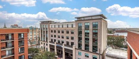 A multi-story hotel with a central courtyard, large windows, and a brick facade.