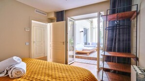 Une chambre d’hôtel comprenant un lit, une salle de bain et un balcon avec un espace salon.