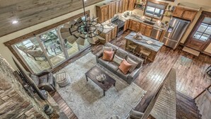 Un vaste espace de vie de style loft, doté d’une grande cuisine ouverte, de planchers en bois et d’un haut plafond avec des poutres apparentes.