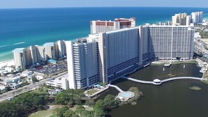 Ein Hochhaus-Hotel mit mehreren Etagen, einem zentralen Innenhof mit Pool und Blick auf den Ozean.