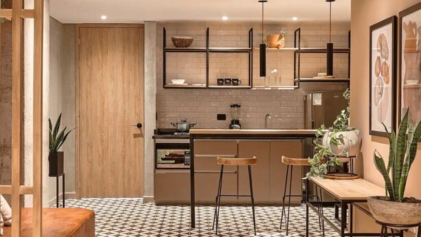 A modern kitchen with a central island, bar stools, and a dining table. - PRIME LOCATION / Mosaic Studios Barranquilla P-1 (Barranquilla)