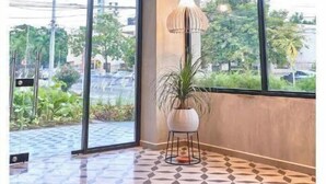 A spacious lobby with large windows, geometric patterned flooring, and multiple hanging pendant lights. - PRIME LOCATION / Mosaic Studios Barranquilla P-1 (Barranquilla)