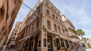 Un bâtiment historique à étages, doté de grandes fenêtres et de balcons.