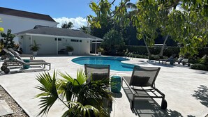 Un área de piscina con sillones de descanso y una piscina pequeña.