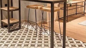 Eine moderne Küche mit Holztisch, hängenden Pendelleuchten und einem Musterboden.