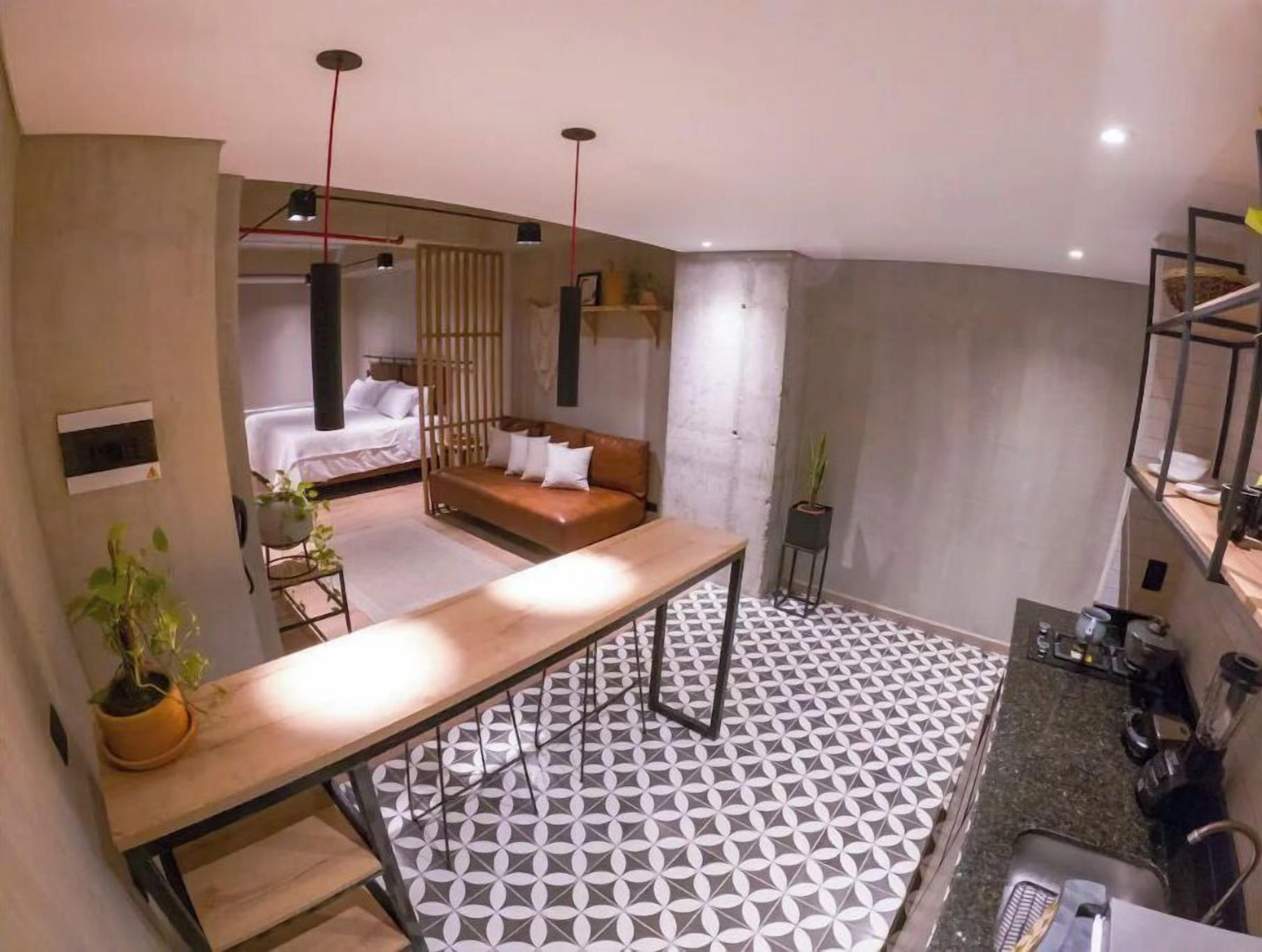 A modern interior with a kitchen, dining area, and a bedroom.