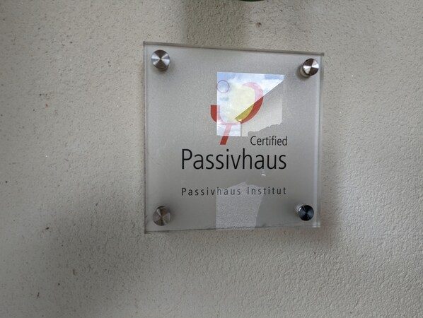 A glass plaque with the text 'Certified Passivhaus' and 'Passivhaus Institut' mounted on a wall. - Unique, Spacious, Self-Built Eco House with Huge Garden and Movie Room (Andover)