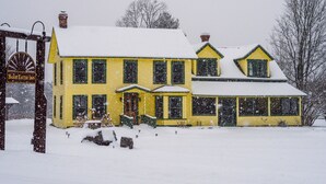 A yellow building with a snow-covered roof and a sign that reads 'Bark Eater Inn.' - Forest Suite - 2 OR 3 Rooms + Bath (Keene)