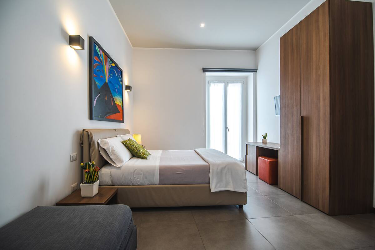 A modern bedroom with a bed, bedside table, and a large wardrobe.