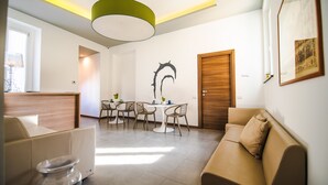 Una sala de estar moderna con un sofá, una mesa de comedor con sillas y una puerta de madera.