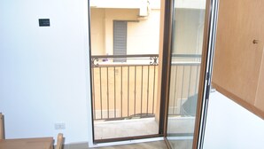 A room with a sliding glass door leading to a balcony with a metal railing. - Agrigento Centre - 1-bed Apartment - Sleeps 4 (Agrigento)