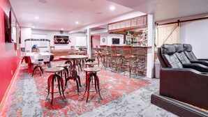 A modern kitchen with a bar area, a massage chair, and a dining area with stools. - 4 Bed/3 Bath, Sleeps 12! 20 min DIA, Pets-Large yard; Great for Families! (Commerce City)