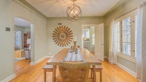 Un comedor con una mesa de madera, sillas y un adorno en la pared.