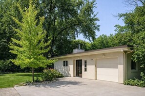 A single-story building with a garage, a chimney, and a well-maintained lawn.