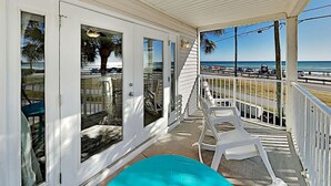 A covered porch with white railings, a turquoise pool, and a view of the beach and ocean. - End Unit Condo | Beach Views | Pool & Hot Tub (Destin)