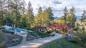 A two-story house with a red-tiled roof, surrounded by a well-maintained garden and a swimming pool. - Stunning Dry Creek Road Estate (Healdsburg)