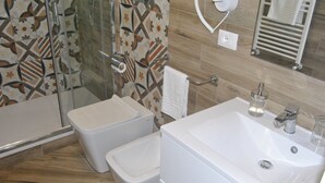 Een badkamer met douche, toilet en wastafel.