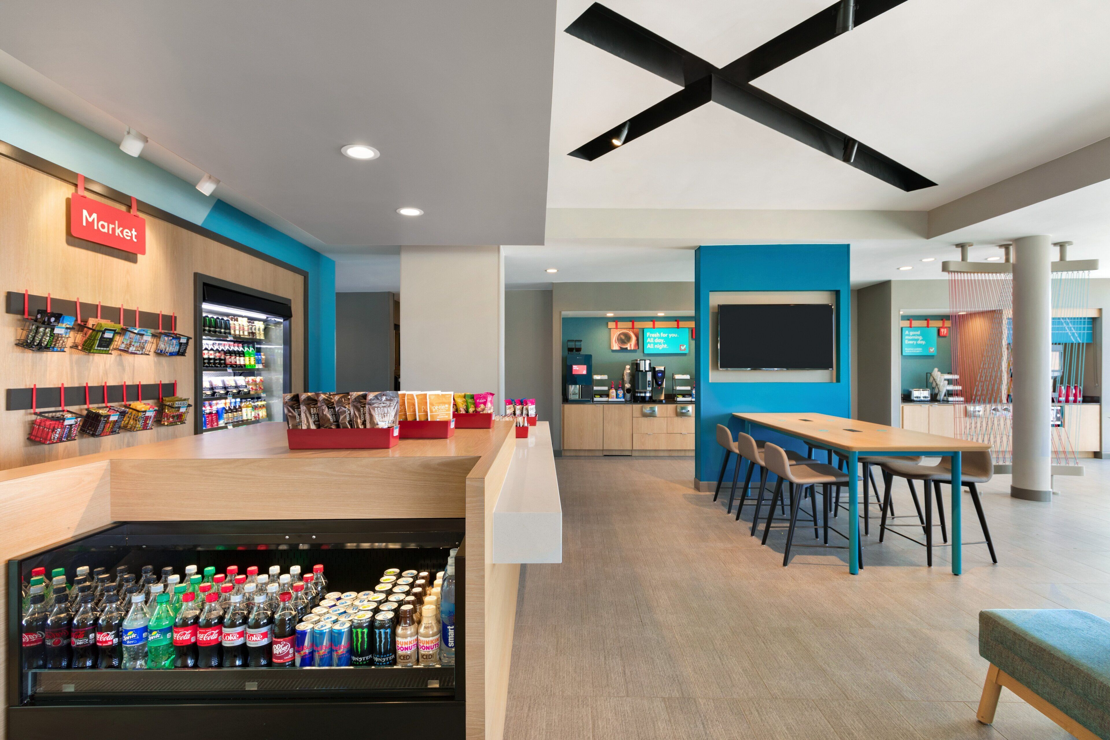 A modern indoor space with a market area, seating, and a counter.