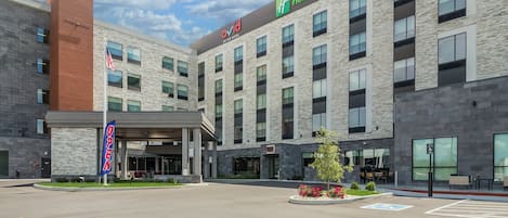 A Holiday Inn & Suites building with a modern design, featuring a brick facade and large windows.