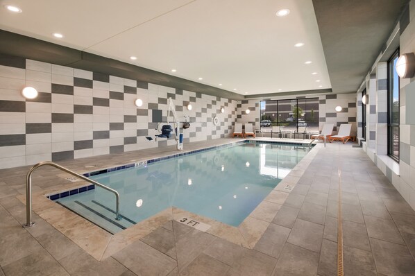 An indoor swimming pool with a tiled wall, a lifeguard chair, and a sun chair. - avid hotel Mt Juliet – Nashville Area by IHG (Mount Juliet)