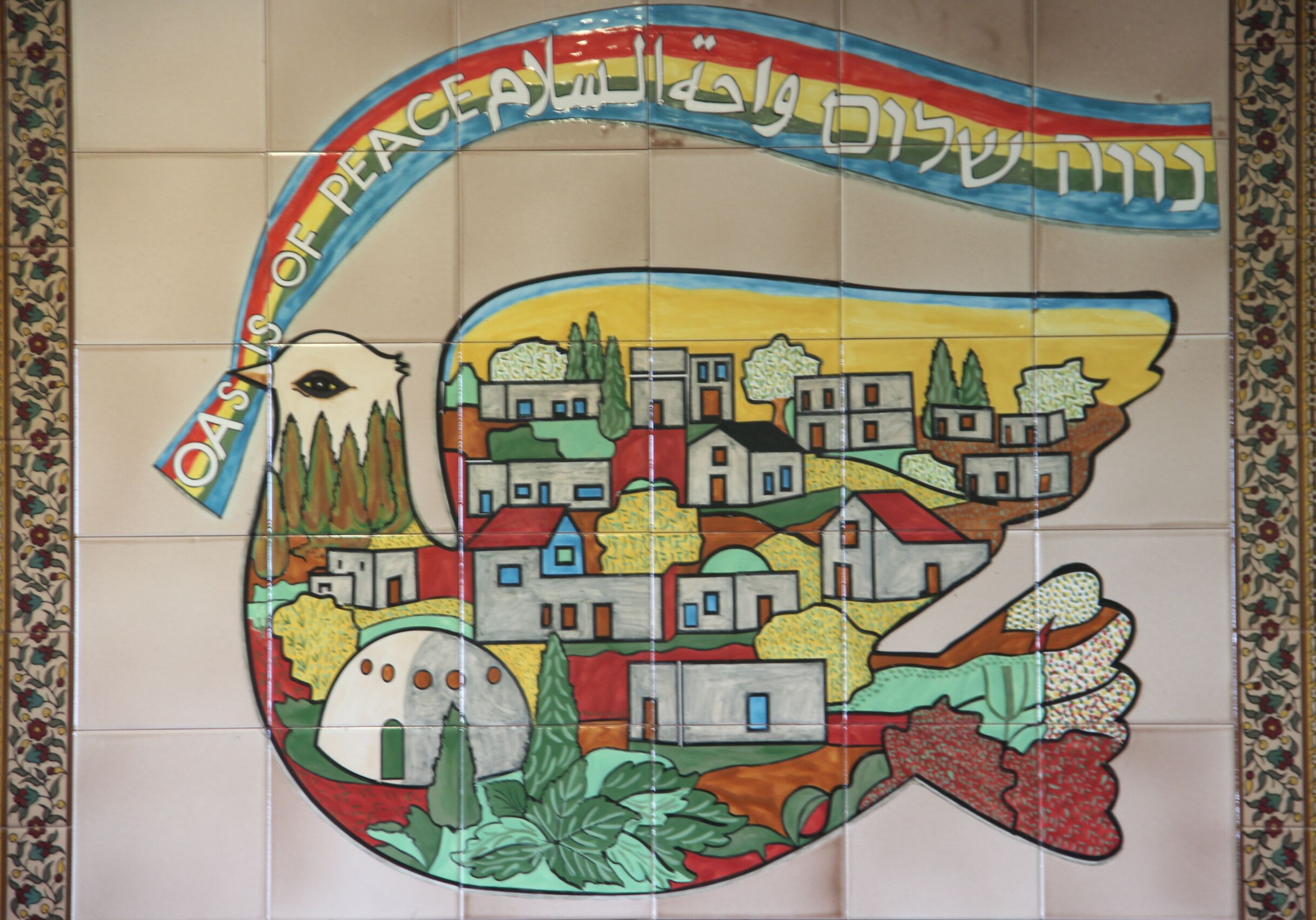 A colorful mosaic with a rainbow and text in multiple languages, including Hebrew.
