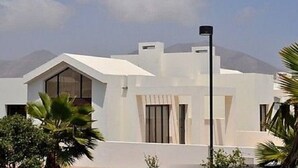 Un edificio moderno e bianco con tetto spiovente, ampie finestre e un'asta sventolante.
