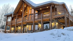 A large log cabin with multiple balconies and stone walls, surrounded by snow. - Best Mtn/Lake views!!! Lodge on esteemed Lakeside Drive! Hot tub! Fido friendly! (Grand Lake)