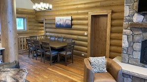 A log cabin interior with a dining area, a fireplace, and a stone accent wall. - Best Mtn/Lake views!!! Lodge on esteemed Lakeside Drive! Hot tub! Fido friendly! (Grand Lake)
