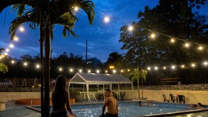 A pool area with string lights, a covered seating area, and a palm tree. - Glamping Lagos de Venecia (Santa Rosa de Cabal)
