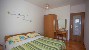 A bedroom with a bed, a wooden wardrobe, a desk with a mirror, and a door. - AGATA One-Bedroom Apartment 4 (Banjole)