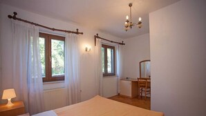 A bedroom with a bed, a desk, a chair, a mirror, and two windows with curtains. - AGATA Two-Bedroom Apartment 5 (Banjole)