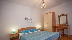 A bedroom with a bed, nightstands, a dresser, a mirror, and a chandelier. - AGATA Two-Bedroom Apartment 6 (Banjole)