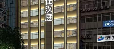 A hotel building with multiple floors and a prominent sign.