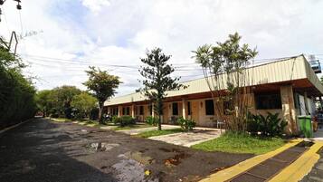A building with a flat roof and a covered outdoor area with chairs and tables.