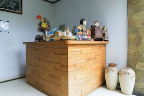 Reception area with a welcoming desk, vase, books, and decorative figurines.