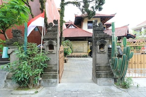 Traditional entrance to a culturally significant site, flanked by stone pillars with intricate carvings.