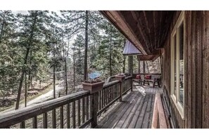 Enjoy the serene forest views from this deck with a railing overlooking the surrounding woods.