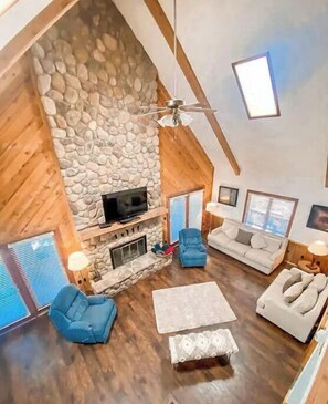 Cozy living area with a stone fireplace, TV, and comfortable seating.